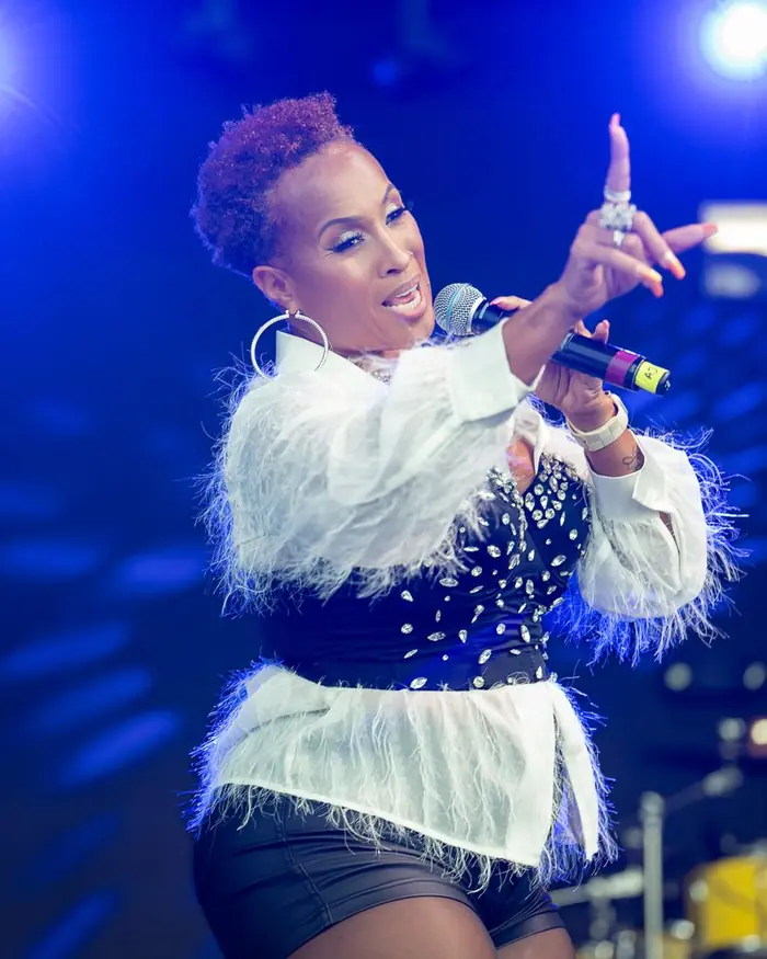 Performer singing on a blue-lit stage