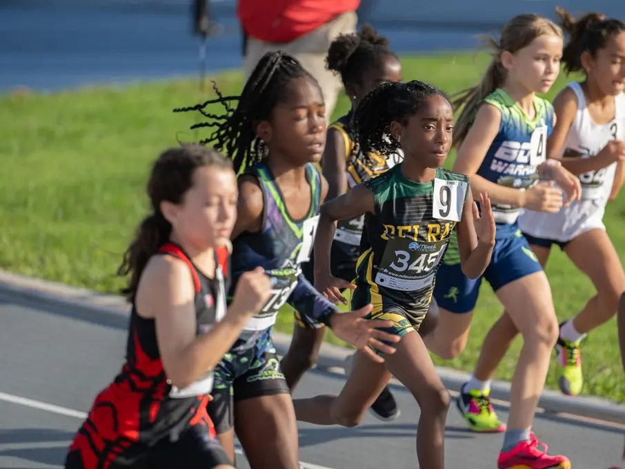 Pack of young runners leaning into a turn