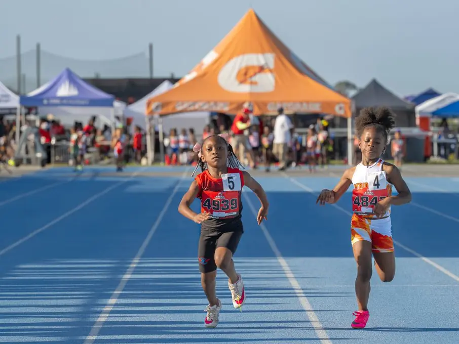Two young sprinters racing toward the finish