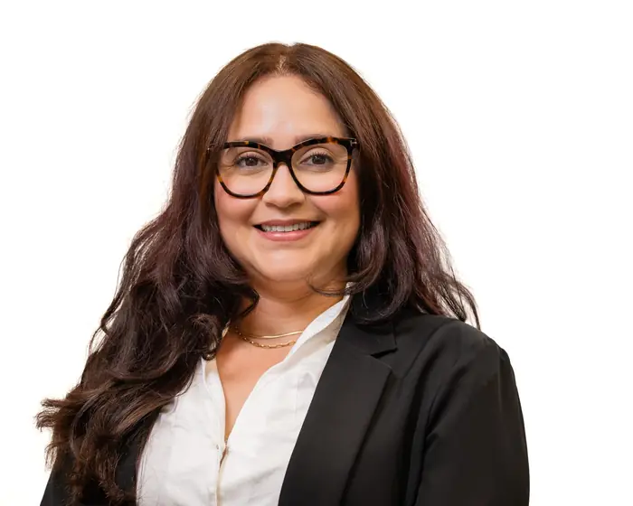 Headshot of a smiling woman in glasses and a black blazer