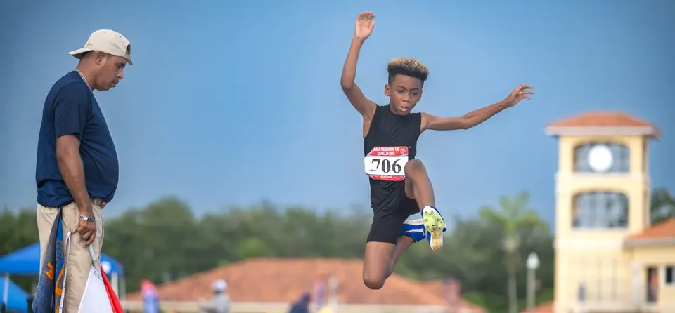 Long jumper flying through the air in front of the clock tower