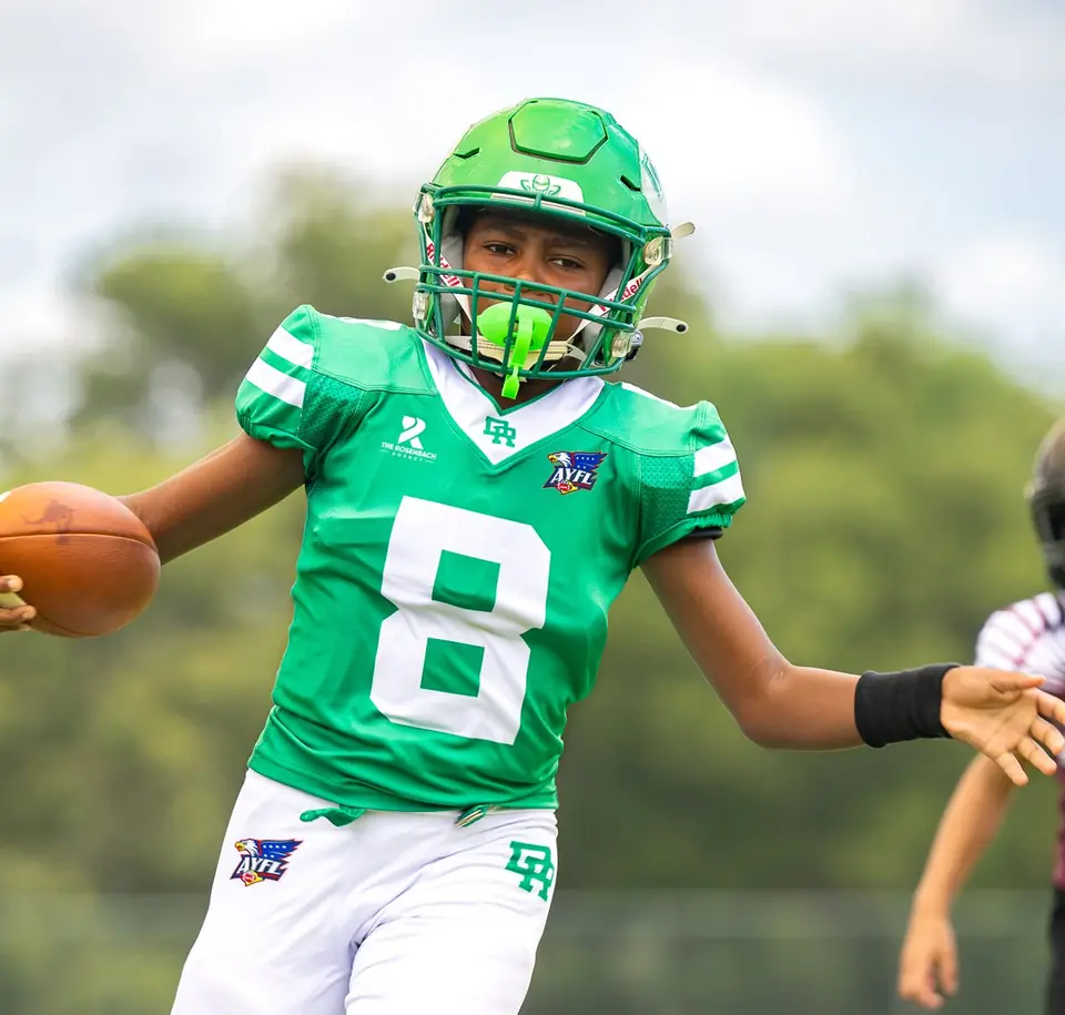 Youth football player number 8 running with the ball
