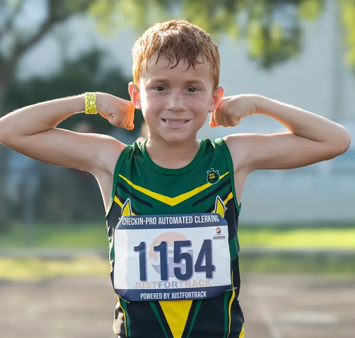 Young runner with hands behind his head on the track