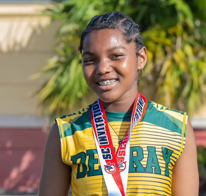 Smiling Delray athlete wearing her medal