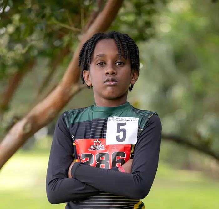Athlete with arms crossed under a tree