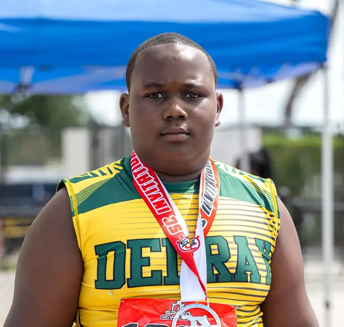 Delray athlete wearing his medal on the track