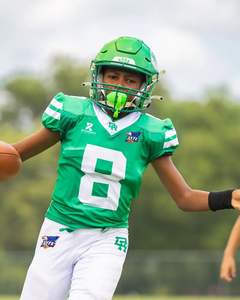 Youth football player carrying the ball upfield